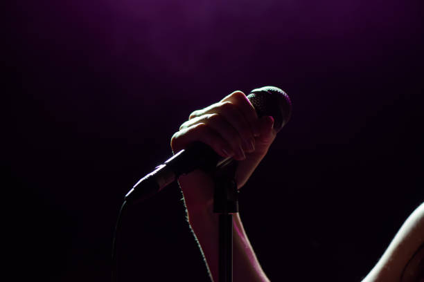 Microphone in hand singer on stage. Singer woman on stage. stock photo