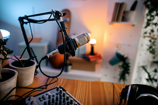 Selective focus of a microphone and audio recording equipments with laptop in a studio to record podcast