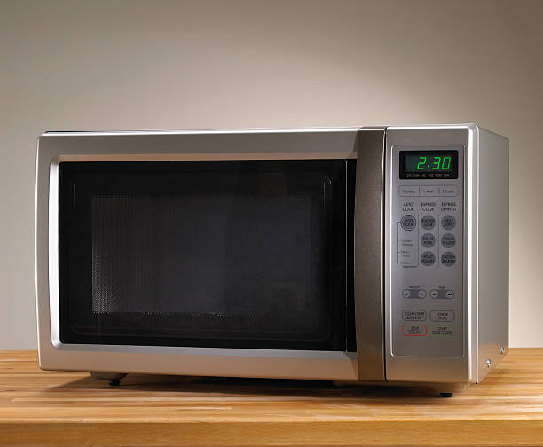 Microwave oven Microwave oven on wooden table with time displayed microwave stock pictures, royalty-free photos & images