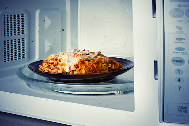 Microwaved Lasagna A plate of leftover lasagna is reheated in a microwave. microwave stock pictures, royalty-free photos & images