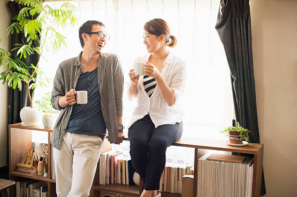 mid adult couple drinking coffee at home - getrouwd stockfoto's en -beelden