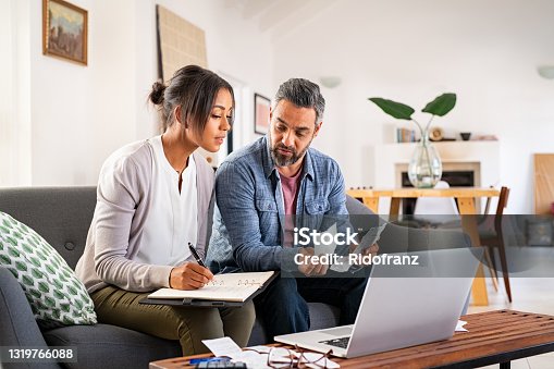 istock Mid adult couple working on home finance 1319766088