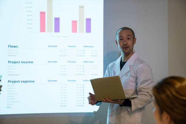 Mid adult doctor giving a speech or presentation to colleagues stock photo