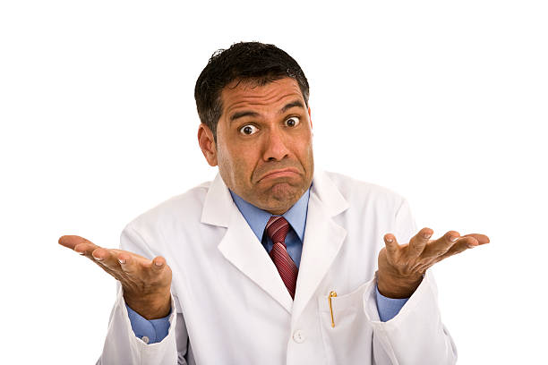 Mid adult male wearing lab coat gesturing making a face stock photo