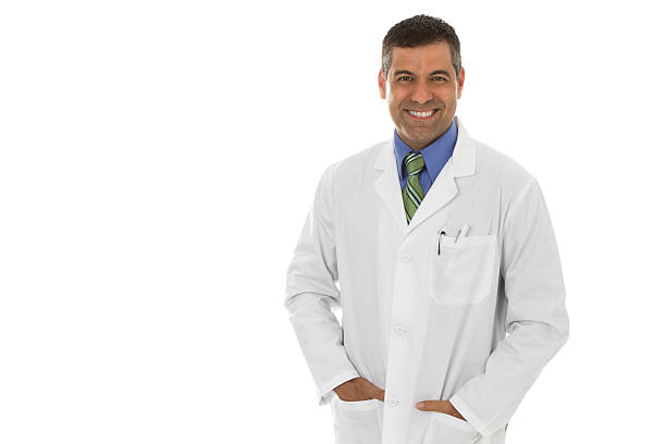 Mid adult male wearing lab coat hands in pockets stock photo