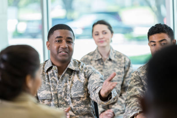 Mid adult soldier talks with a superior officer Serious mid adult African American soldier gestures while talking with a panel of superior officers. military schools stock pictures, royalty-free photos & images