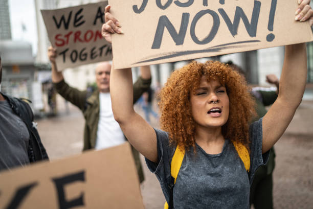 Mid adult woman holding a sign during a demonstration in the street