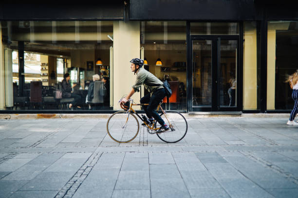 mid aged man commuting on a bicycle through the city stock photo