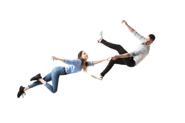 Mid-air beauty. Full length studio shot of attractive young woman and man hovering in air and keeping eyes closed Mid-air beauty cought in moment. Full length shot of attractive young woman and man hovering in air and keeping eyes closed. Levitating in free falling, lack of gravity. Freedom, emotions, artwork concept. hovering stock pictures, royalty-free photos & images