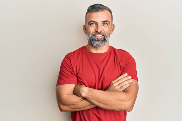Middle age handsome man wearing casual clothes happy face smiling with crossed arms looking at the camera. positive person. stock photo