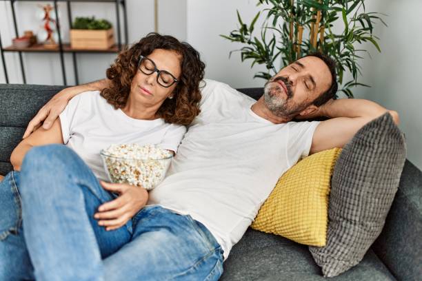 middle age hispanic couple sleeping sitting on the sofa at home. - nap middle age woman bildbanksfoton och bilder