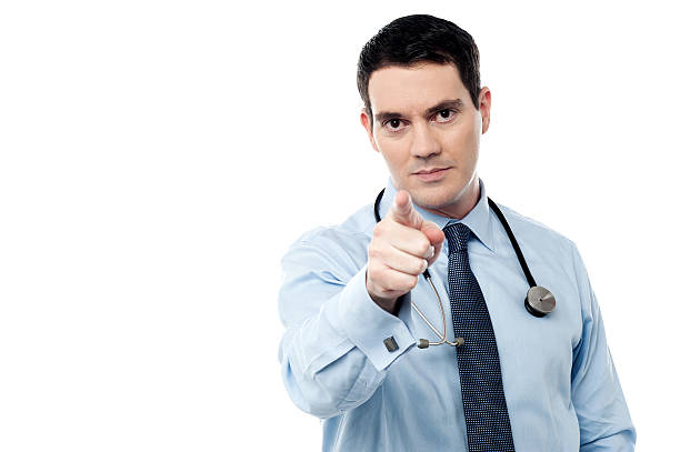 Middle aged doctor pointing at camera stock photo