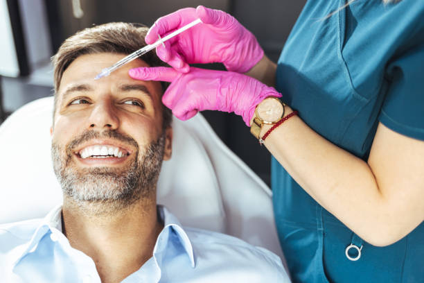Middle aged male client during filler injections in a clinic Filler injection for male face in beauty clinic beard filler stock pictures, royalty-free photos & images