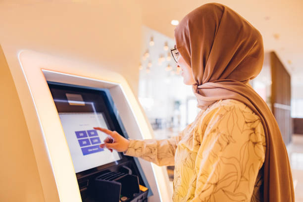 Middle Eastern girl using ATM to withdraw the money stock photo