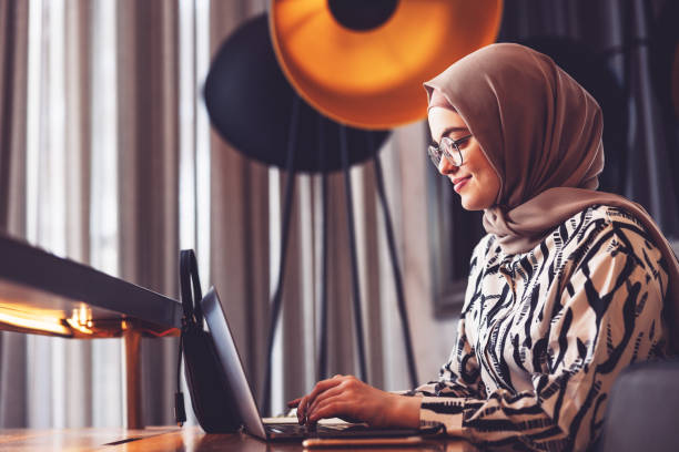 het meisje dat van het middenoosten laptop gebruikt om online te bank - arabic student stockfoto's en -beelden