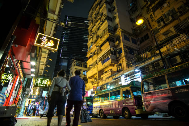 A middle-aged couple walk on the street in the area of Causeway Bay in the evening, Hong Kong stock photo