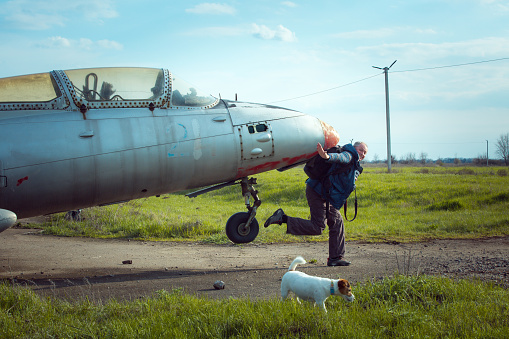 A middle-aged man near an old abandoned Soviet plane. Airplane on the field of the old airport.