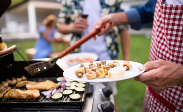 midsectie van familie buitenshuis op tuin barbecue, grillen. - barbecue maaltijd stockfoto's en -beelden