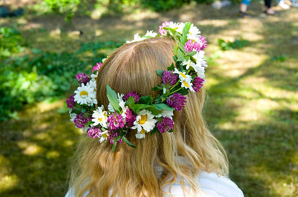 Midsommer girl with flowers in her hair Midsommer (midsommar) flowers in young girls hair. Celebrating Swedish midsommar holiday. swedish girl stock pictures, royalty-free photos & images