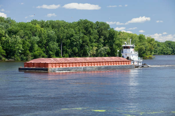 Midsummer Mississippi River Barge A tow is pushing a barge up the Mississippi River. This single barge will be connected with others for a longer haul. barge stock pictures, royalty-free photos & images