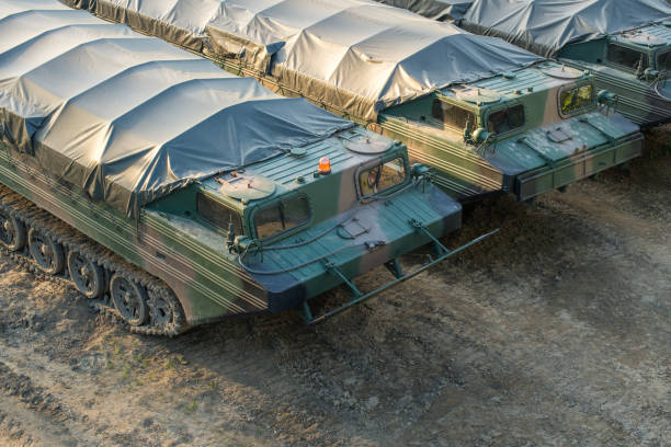 Military amphibious cargo vehicles parked on a battlefield stock photo