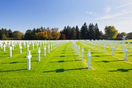 White crosses at the American military cemetery Henri-Chapelle near Aubel in Belgium with blue sky.