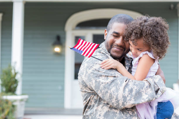 Military dad hugs preschool age daughter Mid adult father is happy to see his little girl after a long overseas military assignment. He picks her up and gives her a big hug. veterans returning home stock pictures, royalty-free photos & images