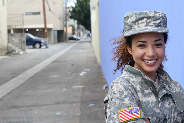 une femme militaire souriant avec un espace de copie - fond bleu marine photos et images de collection