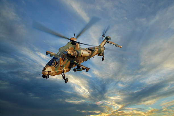 Military helicopter A camouflaged military helicopter in flight against a dramatic sky military helicopter stock pictures, royalty-free photos & images