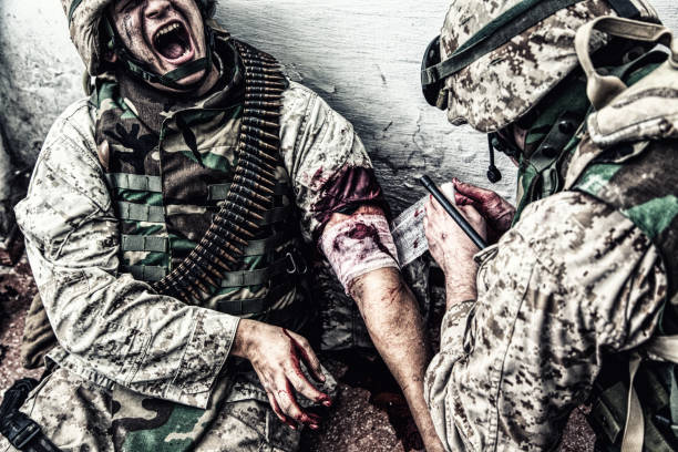 Military medic binding gunshot wound during fight stock photo