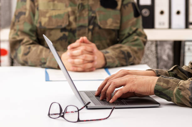 Military officers meeting Military officers meet to discuss recruitment. They are using a laptop. defense industry stock pictures, royalty-free photos & images