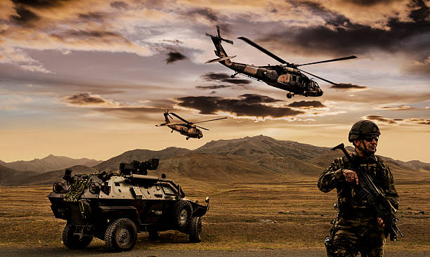 Military Operation Battlefield with a soldier, armored vehicle and flying helicopters. military land vehicle stock pictures, royalty-free photos & images