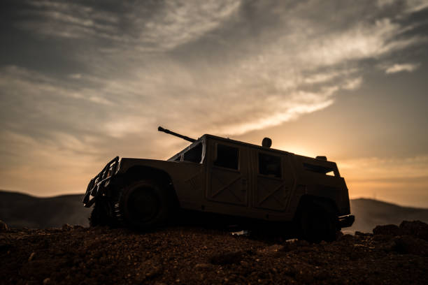 Military patrol car on sunset background. Army war concept. Silhouette of armored vehicle with gun in action. Decorated. Military patrol car on sunset background. Army war concept. Silhouette of armored vehicle with gun in action. Decorated. Selective focus military land vehicle stock pictures, royalty-free photos & images