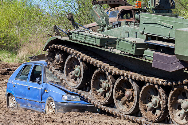 military tank crushes a blue car stock photo
