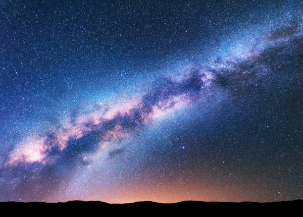 天の川。紫乳白色の幻想的な夜の風景、空の星、黄色のライトと丘の完全な。光沢のある星です。宇宙の美しい景色。星空と宇宙の背景。天体写真。 - 天の川 ストックフォトと画像