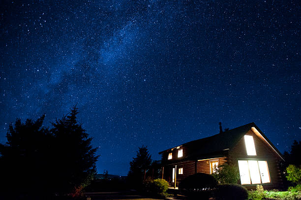 Milky way over a cozy cabin stock photo