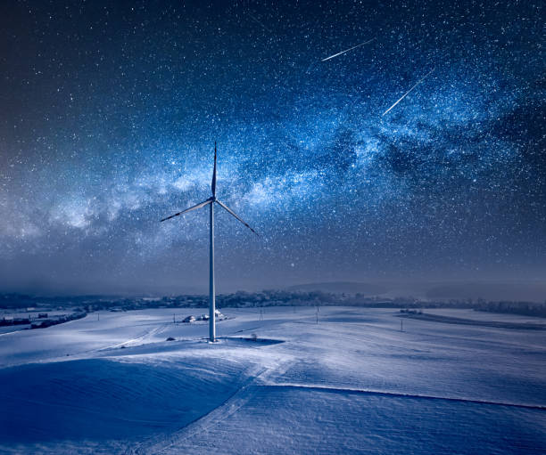 Milky way over wind turbine. Night sky at winter. stock photo