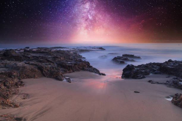 Milky way shimmers over the ocean water stock photo