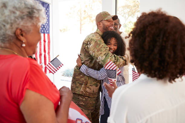 Millennial black soldier embracing his family after returning home,close up, selective focus  soldiers returning home stock pictures, royalty-free photos & images