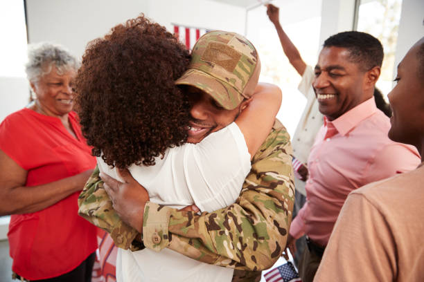 Millennial black soldier returning home embracing family members,close up  soldiers returning home stock pictures, royalty-free photos & images
