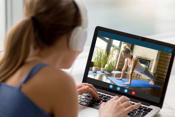 Millennial girl watch yoga training on laptop online Back view of millennial girl relax at home enjoy yoga online training practice course on laptop, young woman watch fitness sports workout video using modern internet application on computer online wellness coach stock pictures, royalty-free photos & images