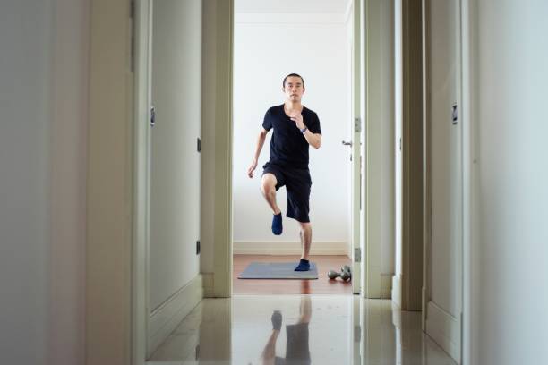 Millennial man exercising at home stock photo
