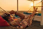 istock Millennial woman rests lying on a hammock and enjoying the golden hour 1390059945