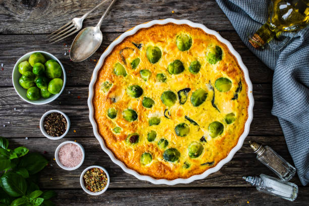 Millet quiche with brussels sprouts and ricotta on wooden table stock photo