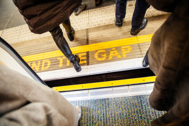 MInd the gap yellow sing in London Tube underground metro London: Directly above view at Mind the gap sign in London Underground metro train station with feets of pedestrians exiting entering metro train separation stock pictures, royalty-free photos & images