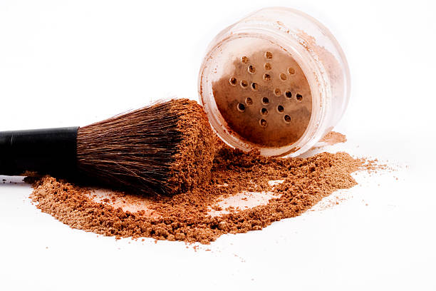 Mineral make-up jar spilled with brush stock photo