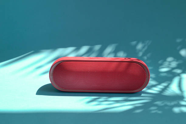 Mini bluetooth red speaker isolated on blue background with shadows. stock photo