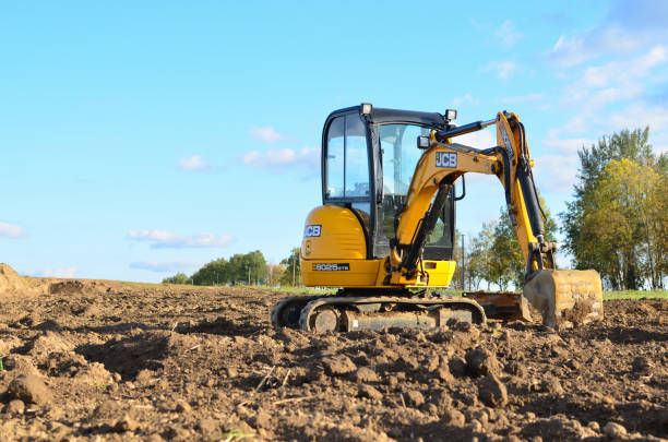 Mini excavator JCB 8025 ZTS digging earth in a field or forest. stock photo