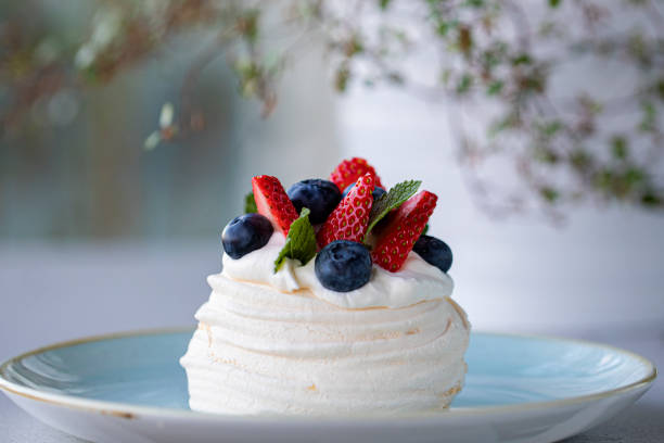 Mini pavlova with strawberries blueberries mint and whipped cream Mini pavlova with strawberries blueberries mint and whipped cream pavlova dessert photos stock pictures, royalty-free photos & images