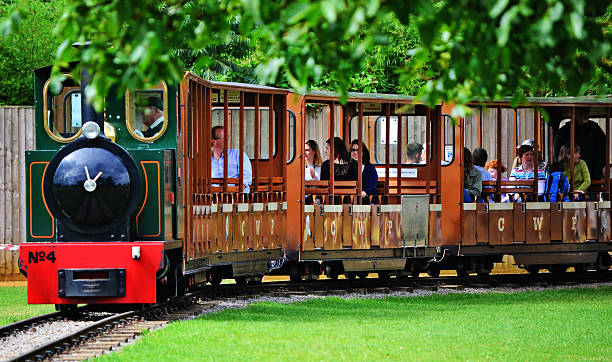 Mini Train Burford, England - September 2, 2015: Mini train taking people around the Wildlife Park in the Cotswolds, United Kingdom. The train driver and other people can be observed onboard the train. wildlife reserve stock pictures, royalty-free photos & images